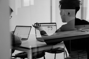 A person working at a desk with a laptop and an external screen